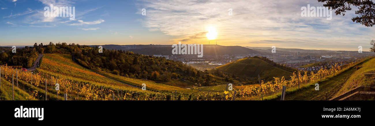 Autumn sunset view of Stuttgart sykline overlooking the colorful vineyards. The iconic Fernsehturm as well as the soccer stadium are visible. The sun Stock Photo
