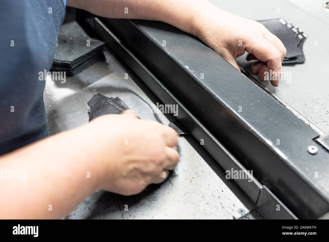 Lowering the edges of parts. Shoe production. Stock Photo