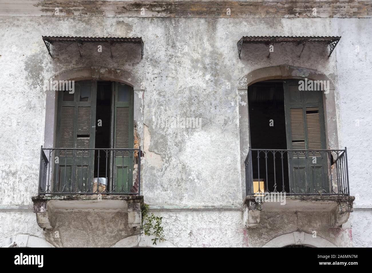 Old Vintage Residential Character Building Exterior Facade with Rusted Symmetrical Balcony Doors in Casco Viejo Old Town, Panama City Stock Photo