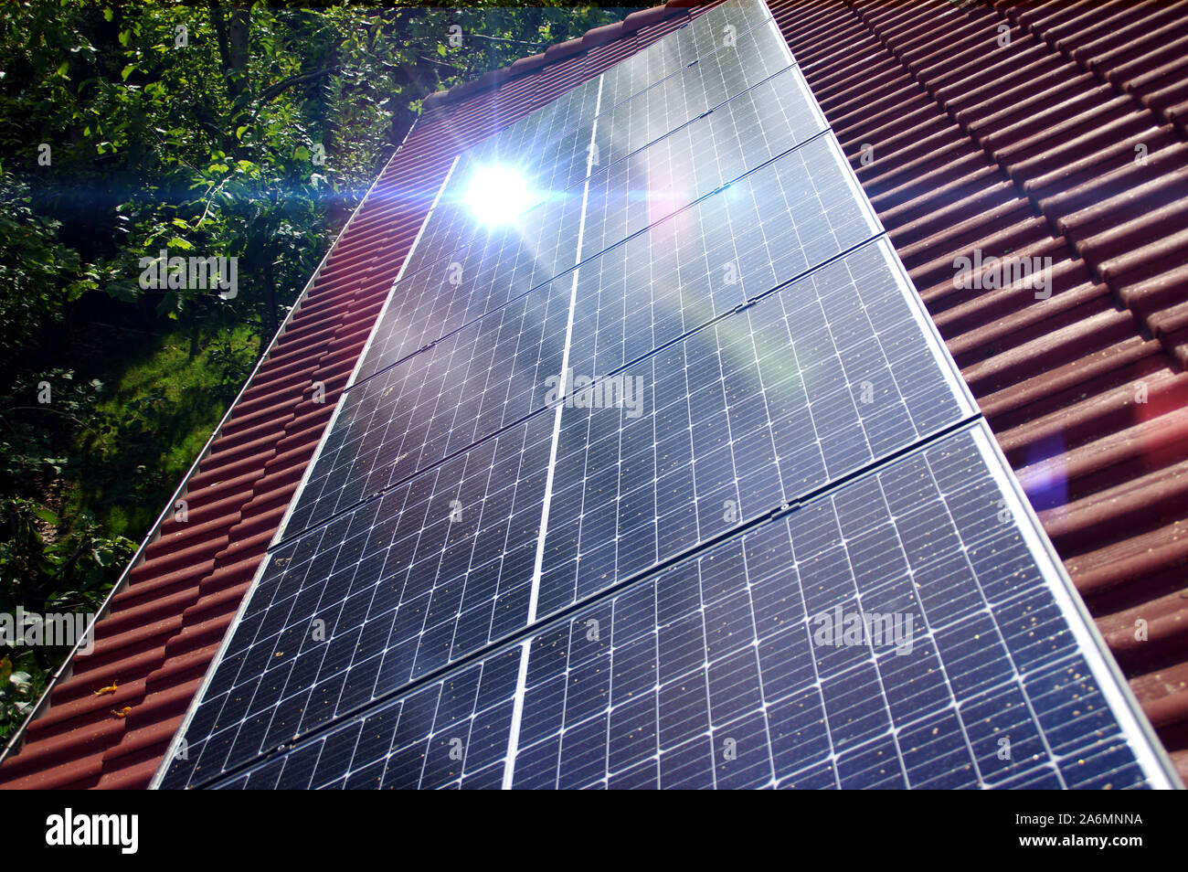 Photovoltaic panels on house roof. Alternative and renewable energy, green power, ecology and solar electricity production. Stock Photo