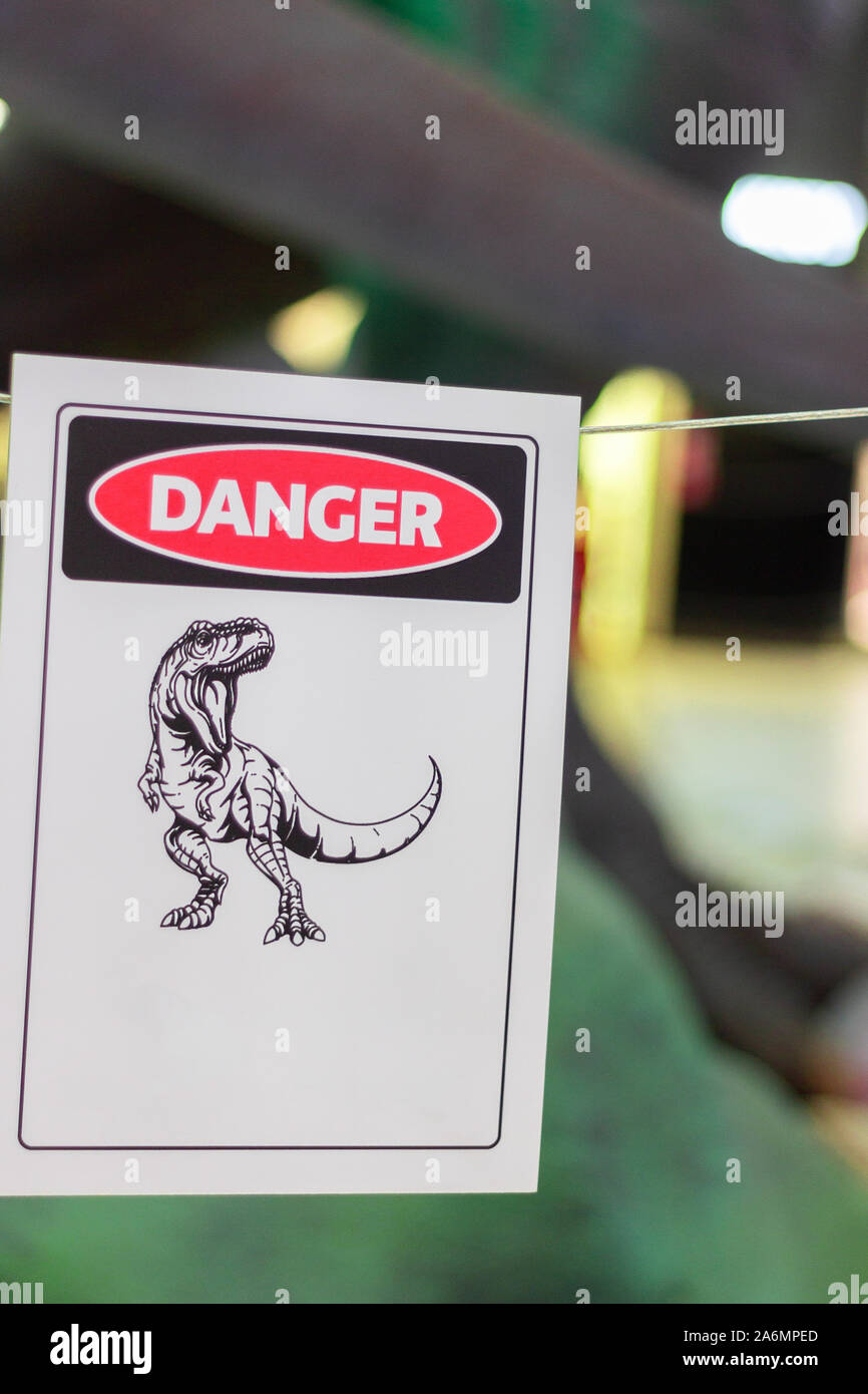 dinosaur sign danger zone symbol caution safety wild Stock Photo - Alamy