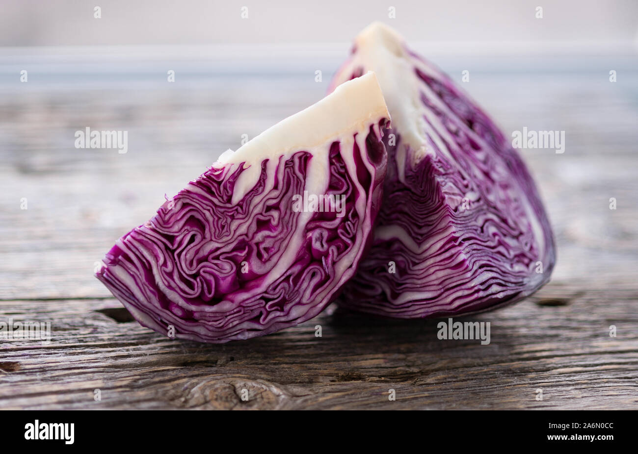 Deep purple  red cabbage .Two quarters lying on the wooden background.Vegetables abstract background. Selective focus.Horizontal with copy space. Stock Photo