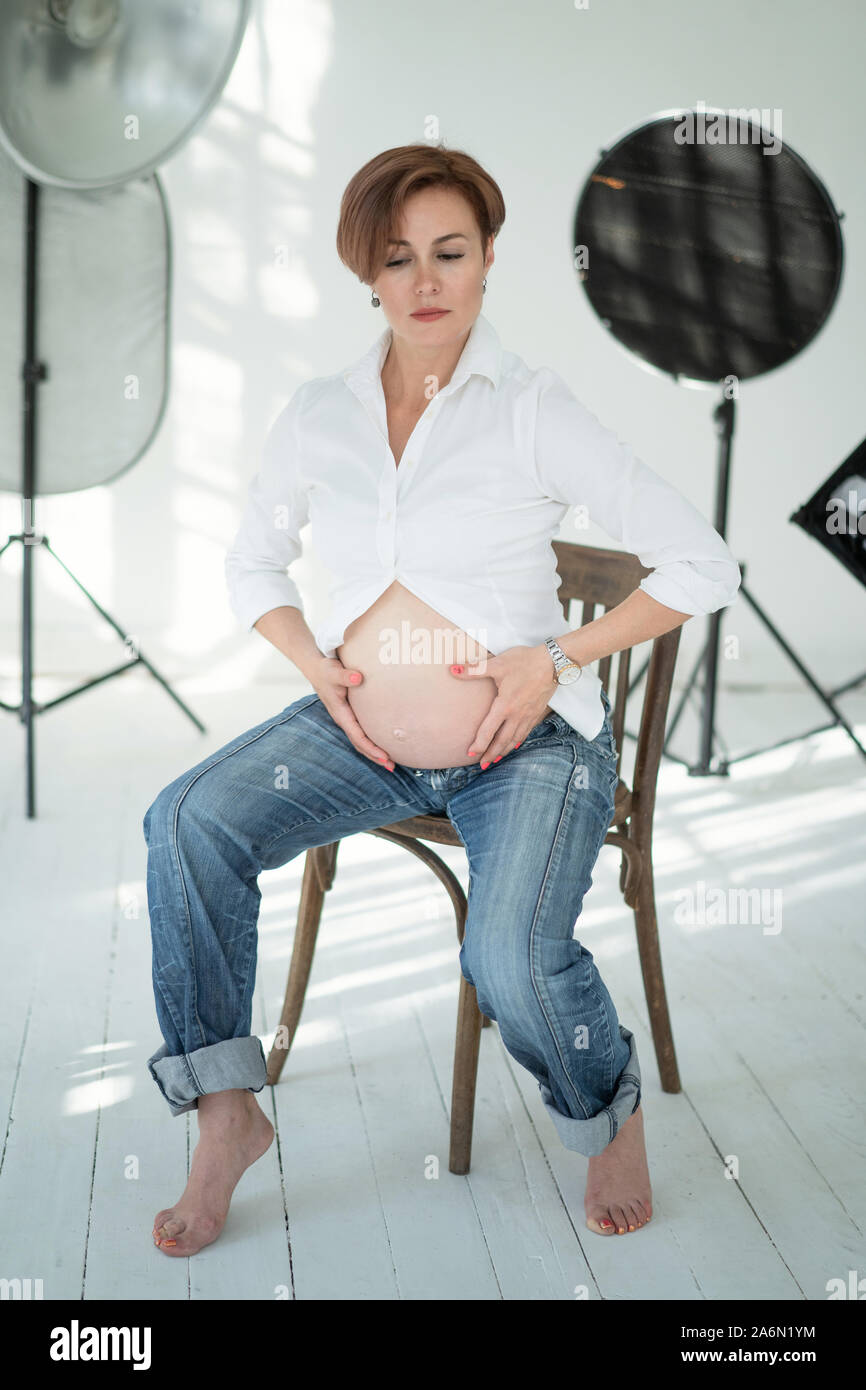 Smiling Pregnant Woman Posing On Chair At Office Stock Photo, Picture and  Royalty Free Image. Image 81038396.