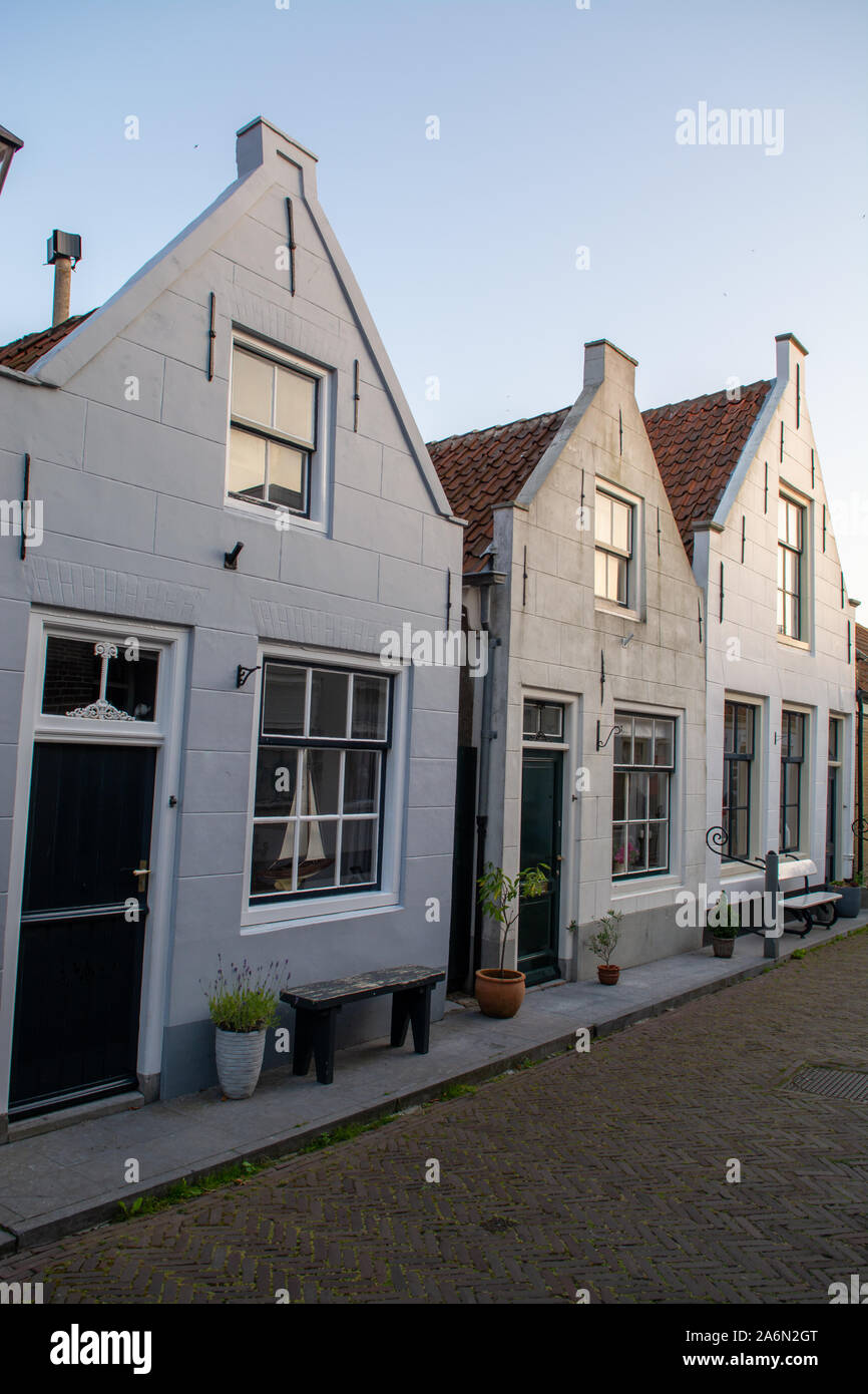 Street view with old houses in small Dutch town Goedereede on sunset