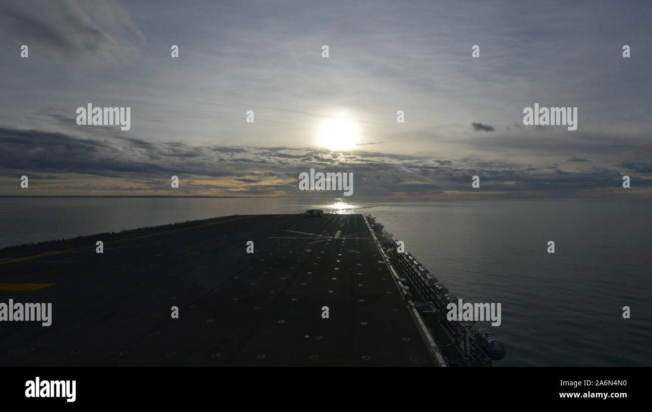 191025-N-BK917-1523 STRAIT OF MAGELLAN (OCT. 24, 2019) The sun rises over the bow of the amphibious assault ship USS Wasp (LHD 1) traversing the Strait of Magellan. Wasp is currently conducting a homeport shift from Japan to Norfolk, Virginia. (U.S. Navy photo by Mass Communication Specialist 2nd Class Eric Shorter) Stock Photo
