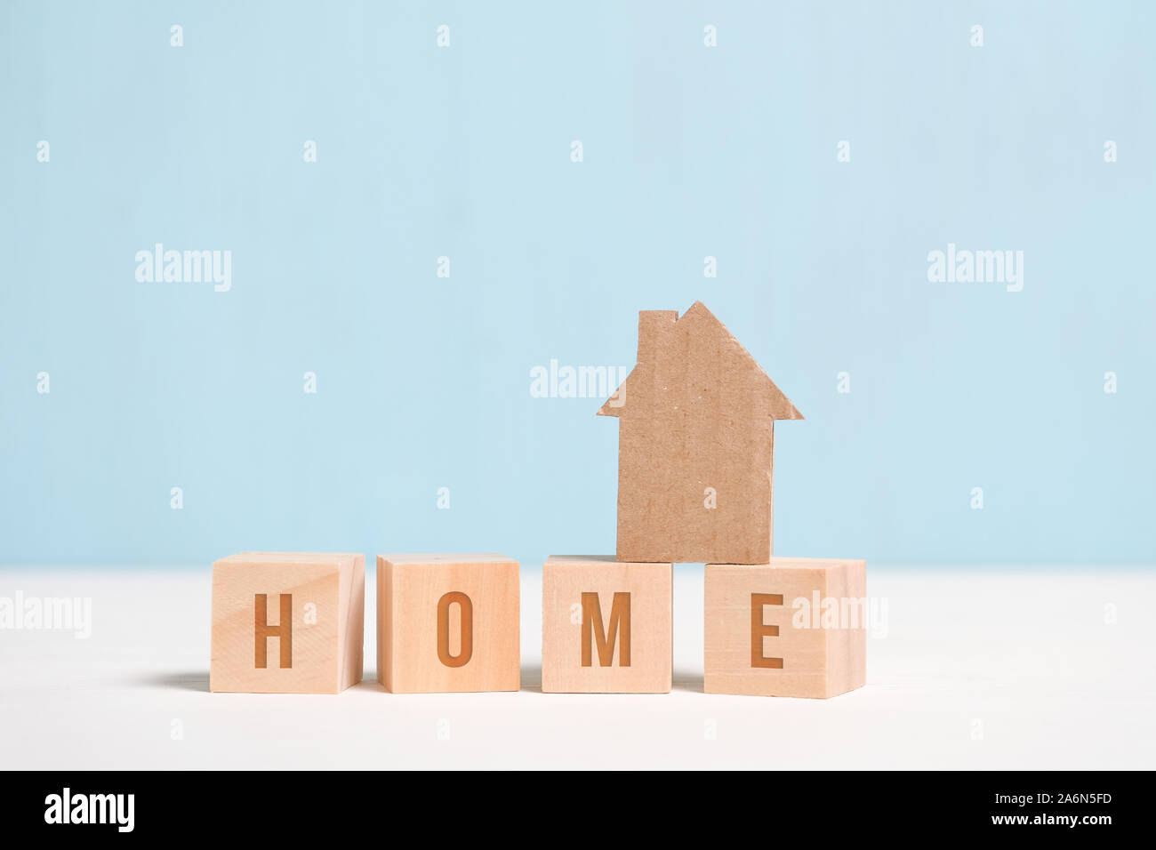 Abstract cardboard house on wooden cubes with the inscription. The concept of a dream about building his house. Close up. Toned. Stock Photo