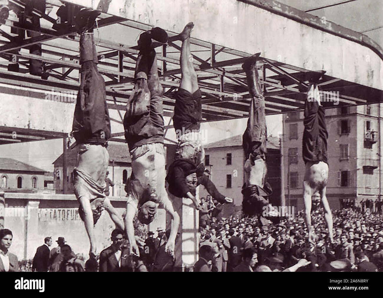 The dead body of Benito Mussolini next to his mistress Claretta Petacci and those of other executed fascists, on display in Milan on 29 April 1945, in Piazzale Loreto, the same place that the fascists had displayed the bodies of fifteen Milanese civilians a year earlier after executing them in retaliation for resistance activity. The photograph is by Vincenzo Carrese. 29 April 1945 Stock Photo