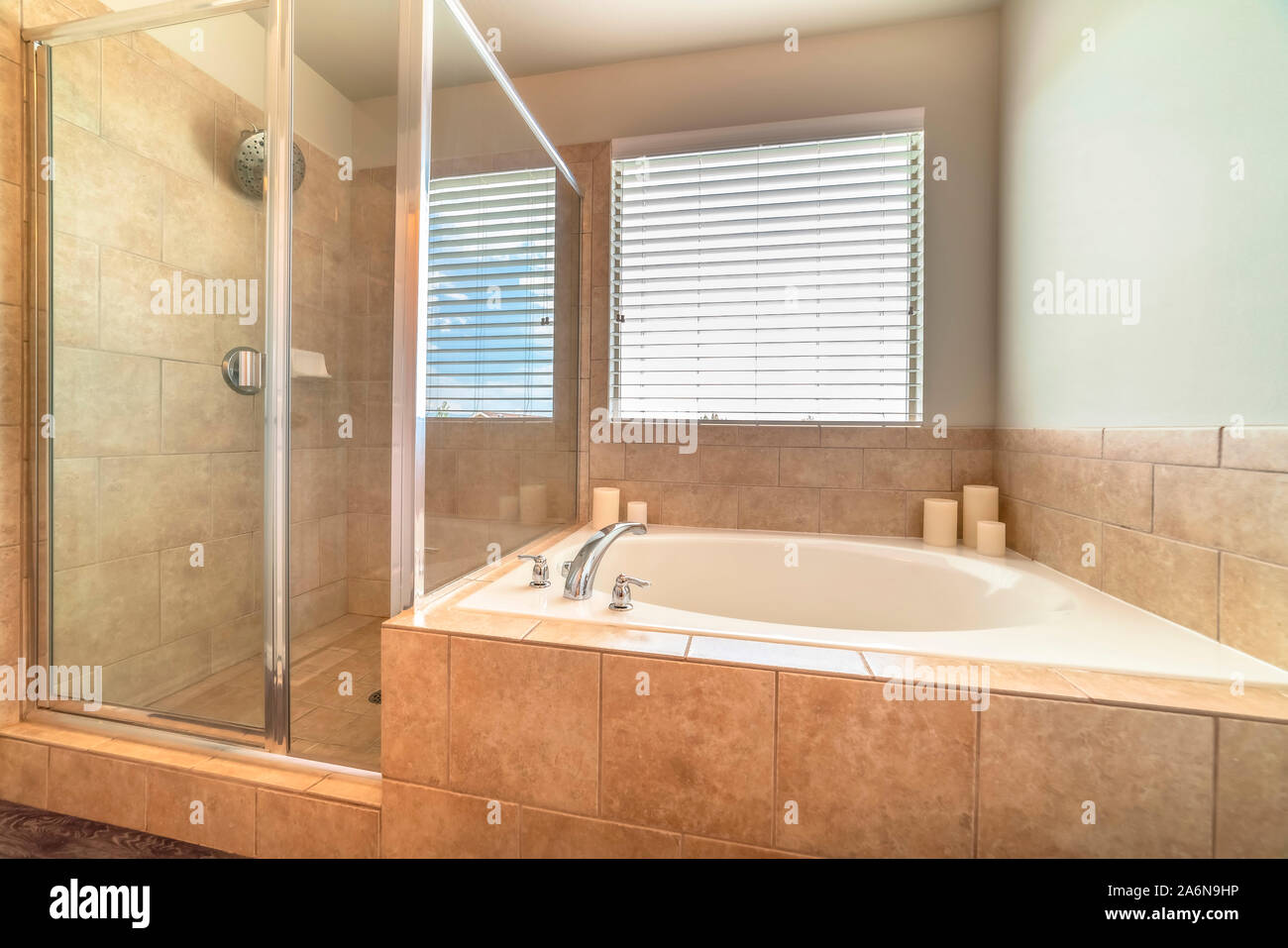 Built in circlar bathtub deside a shower stall inside the bathroom of a