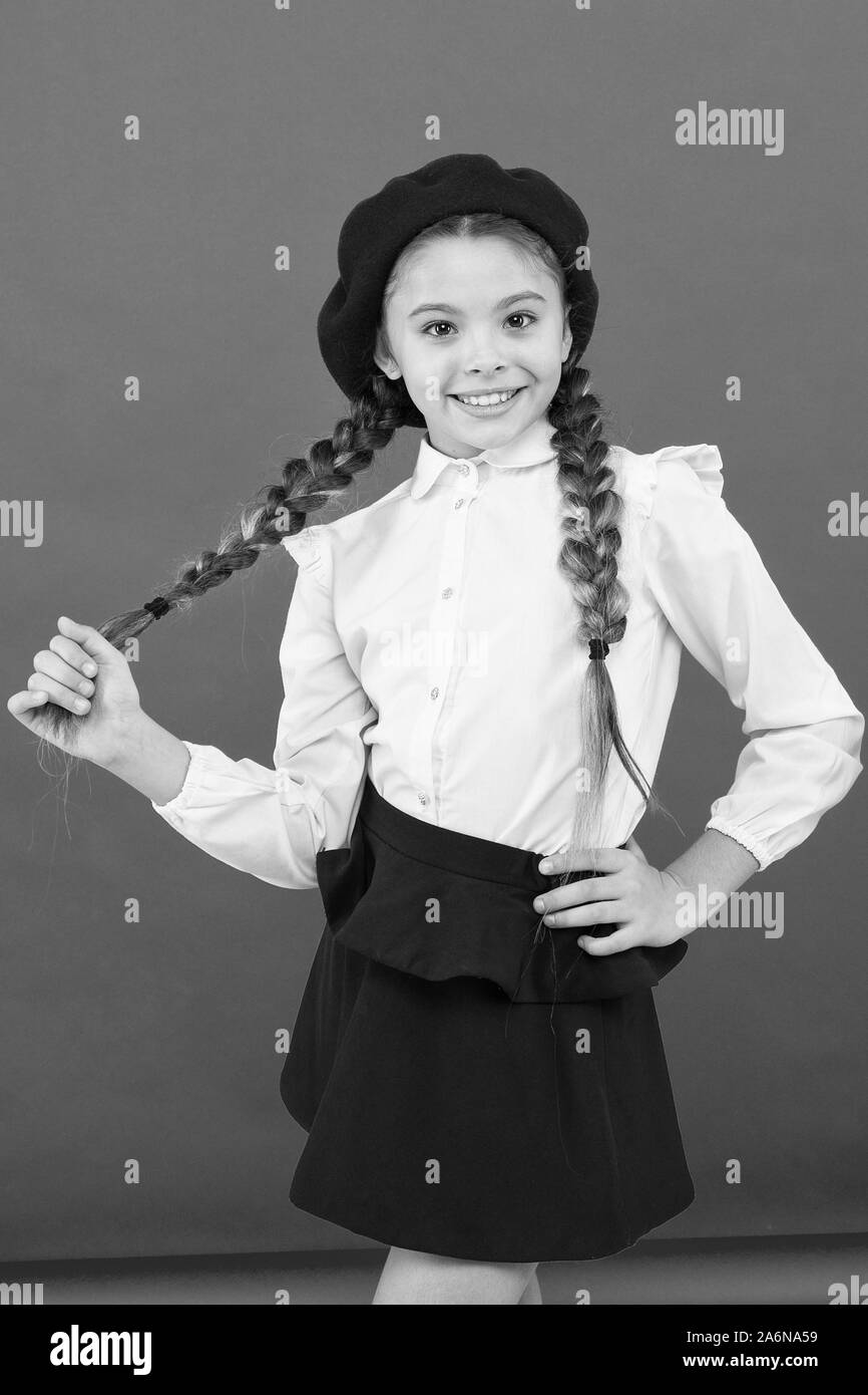 Do you speak french. School fashion concept. Schoolgirl wear formal school uniform and beret hat. Child beautiful girl long braided hair. Fancy style. Little girl with braids ready for school. Stock Photo