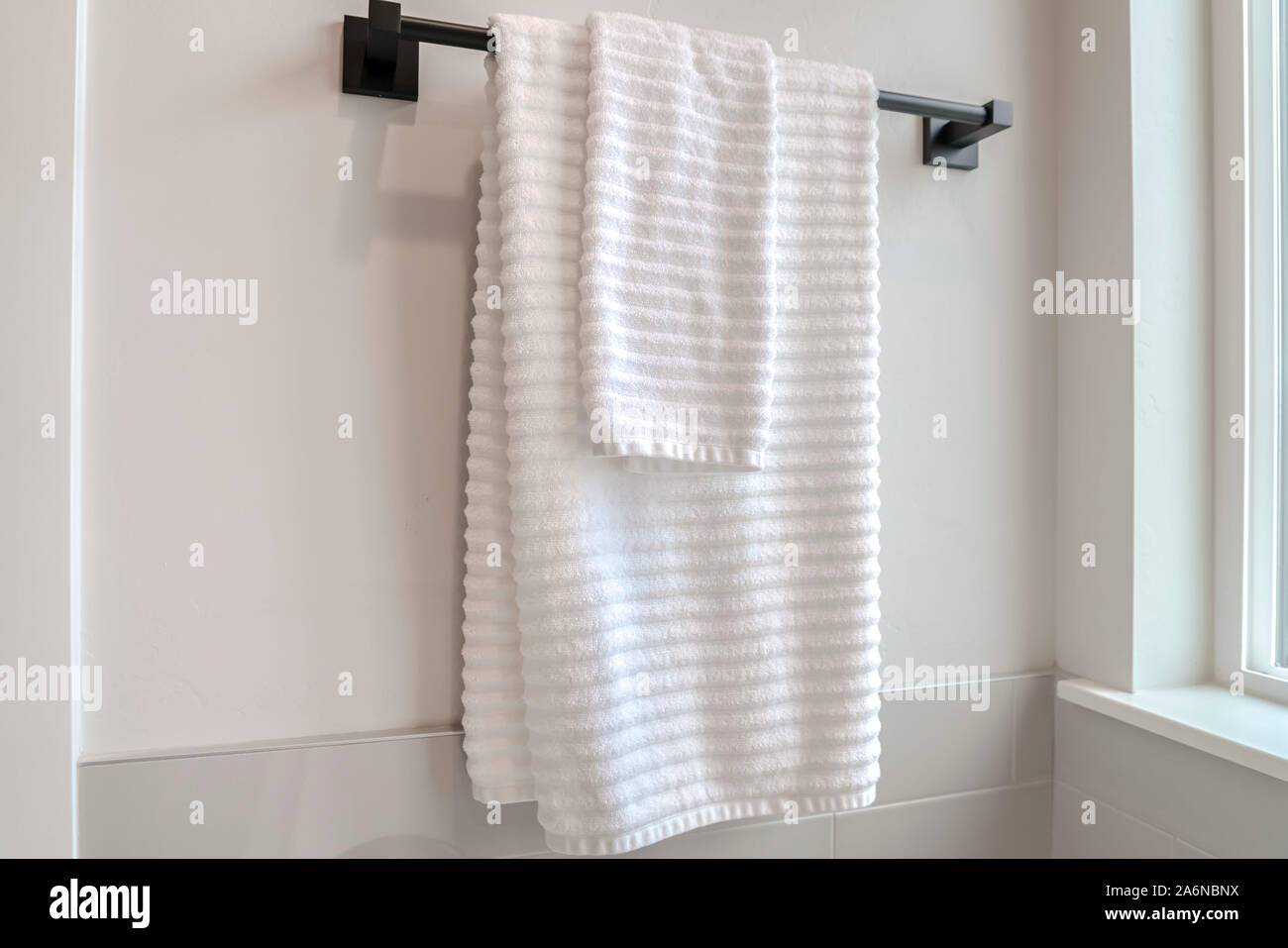 Clean white towels hanging on a towel rail Stock Photo Alamy
