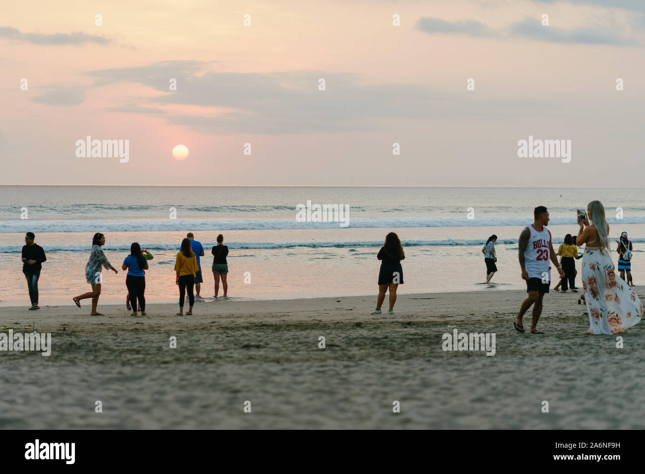 Tourists laying on colorful bean bags to see sunset from Seminyak beach
