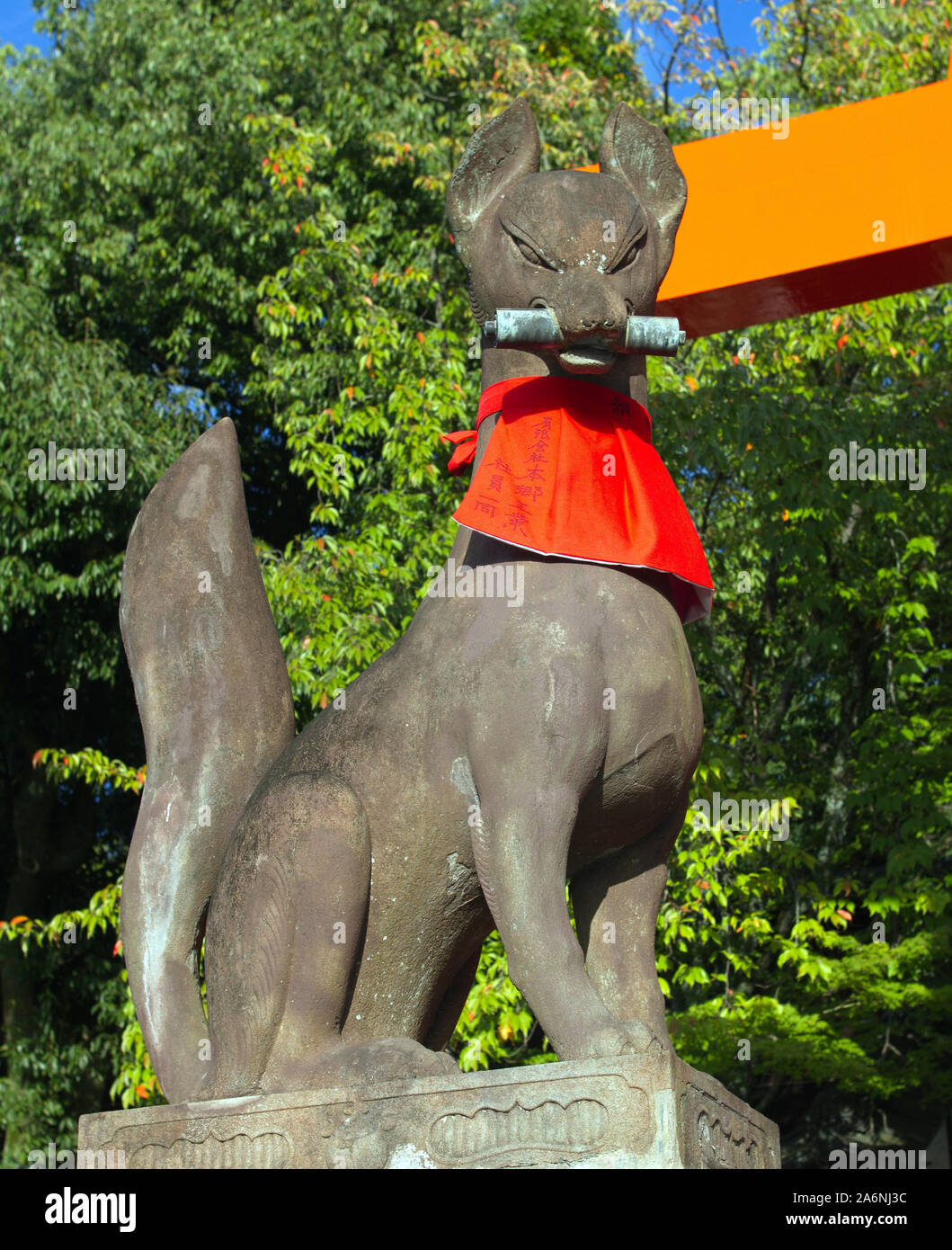 Kitsune fox figure holding scroll of knowledge in its mouth at Fushimi