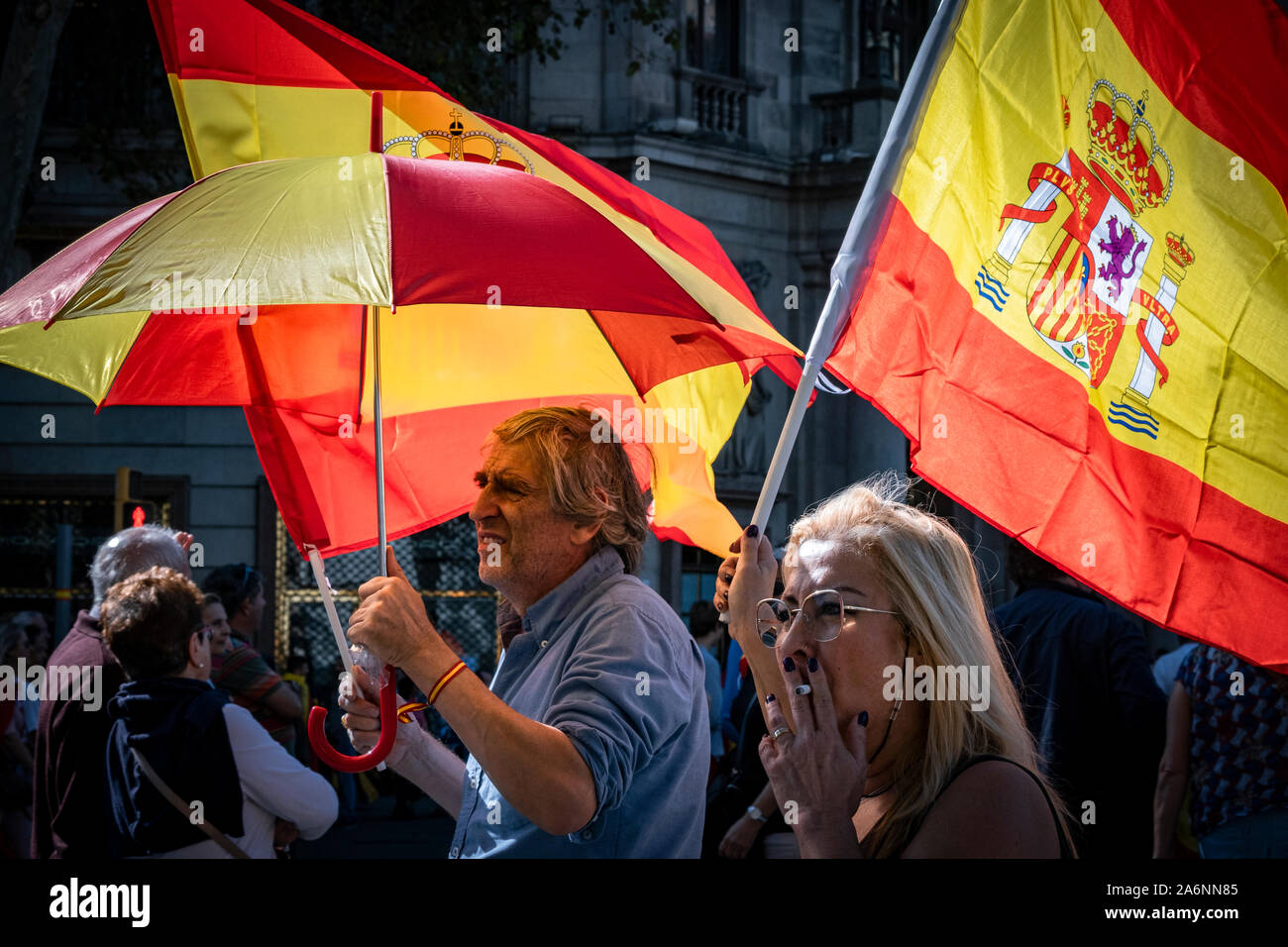 Barcelona, Spain. 27th Oct, 2019. Protesters with Spanish flags and an umbrella during the demonstration.Great constitutional mobilisation in Barcelona. According to sources from the Urban Guard, the demonstration has brought together 80,000 people who have demonstrated under the motto: For Concord, for Catalonia, Enough! Credit: SOPA Images Limited/Alamy Live News Stock Photo