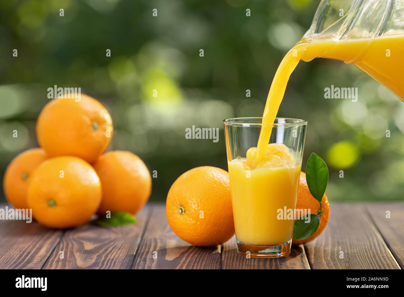 Premium Photo  A glass pitcher of orange juice next to an orange.