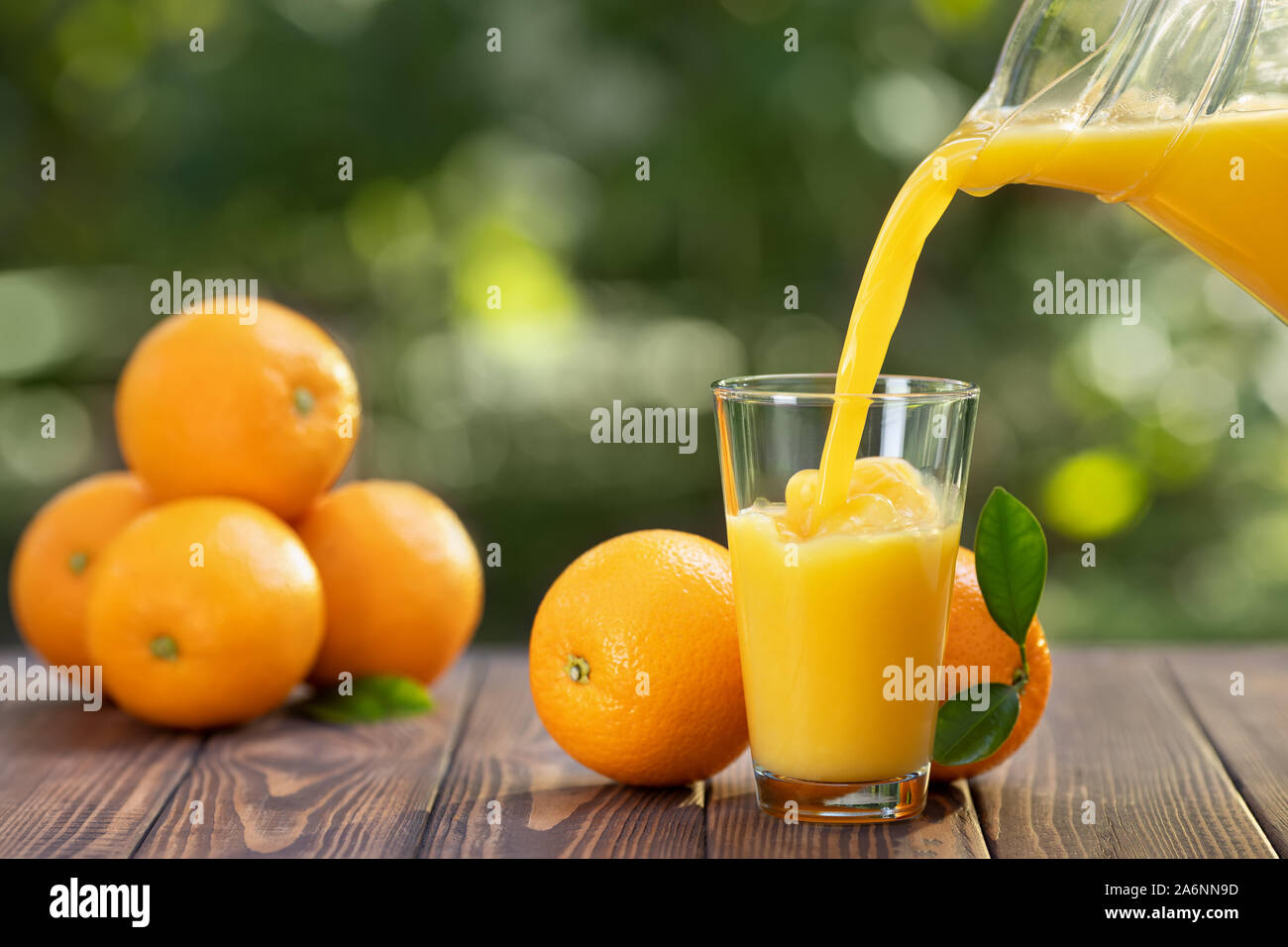 Orange juice pouring from pitcher into glass isolated on white background  Stock Photo by xamtiw