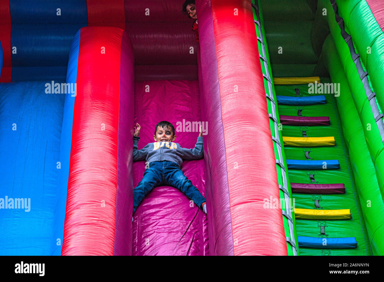 Boy goes down slide as girl watches from above at Dia de los Muertos festival, day of the dead, in San Pedro, California Stock Photo