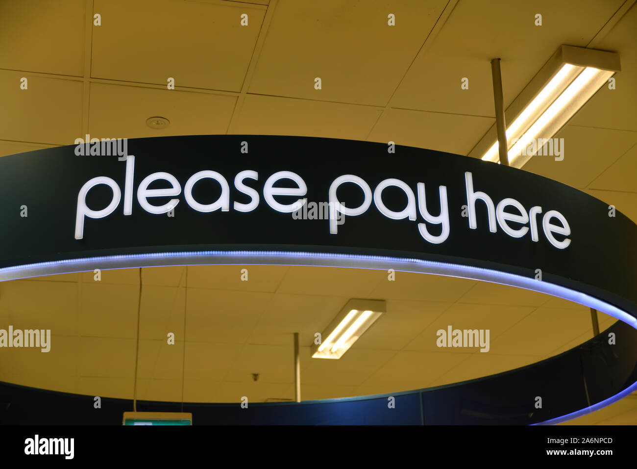Signage in a large department store directs customers to the checkout Stock Photo