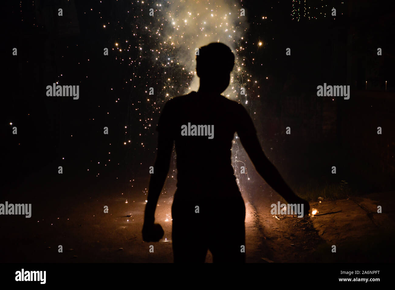 Kolkata, India. 27th Oct, 2019. A man burning firecrackers enjoys the sparkles, light and sound on Diwali in Kolkata.Diwali is known as the 'festival of lights'. It marks victory of good over evil and light over darkness. Diwali celebration has also created a persistent pollution problem for burning firecrackers in India for years. Credit: SOPA Images Limited/Alamy Live News Stock Photo