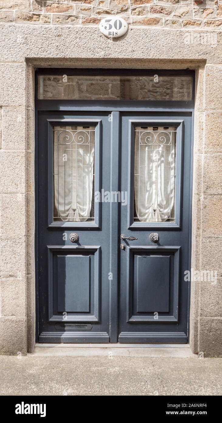 beautiful door full of coquetry, carved and ferronated glass protection, white cotton curtains, number thirty bis Stock Photo