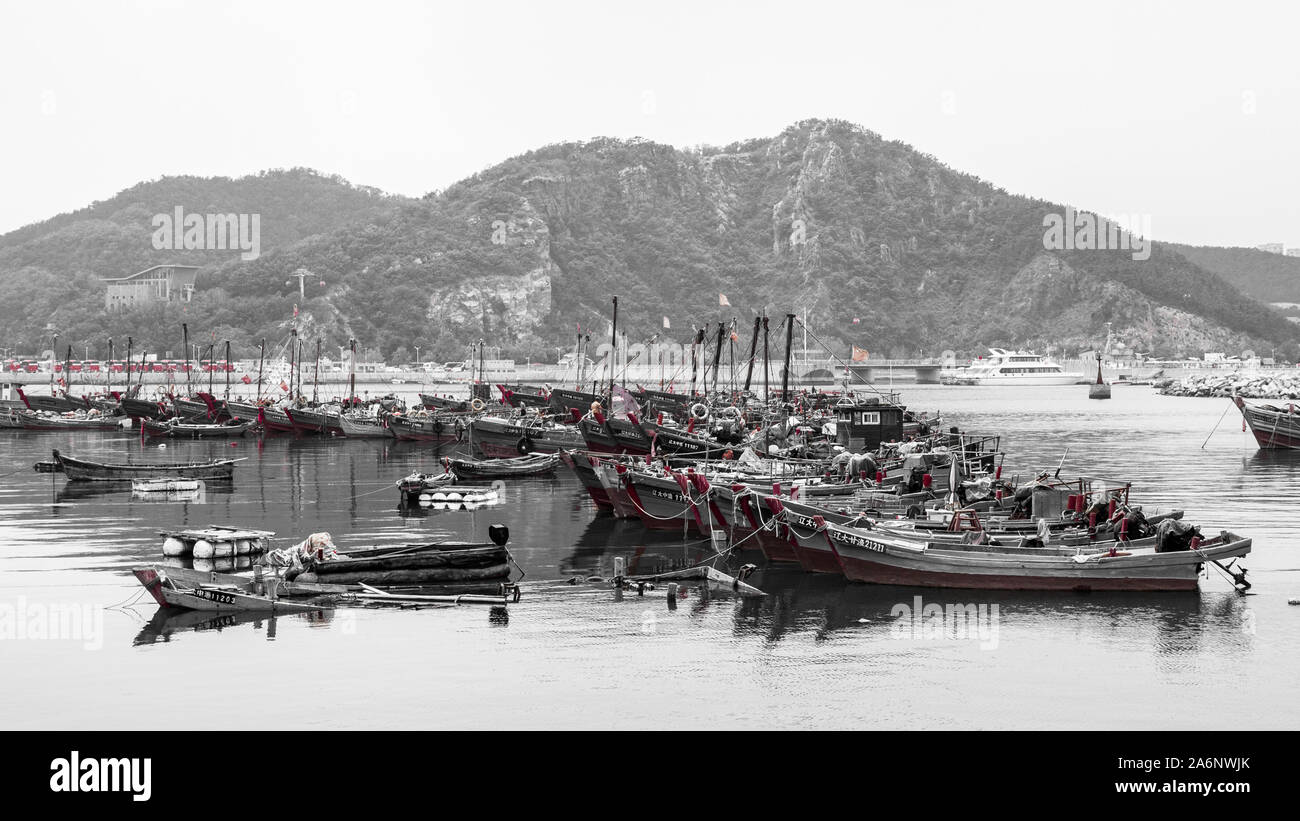RED, Black and white partially desaturated picture of traditional boats in Dalian harbor, China, 22-8-19 Stock Photo