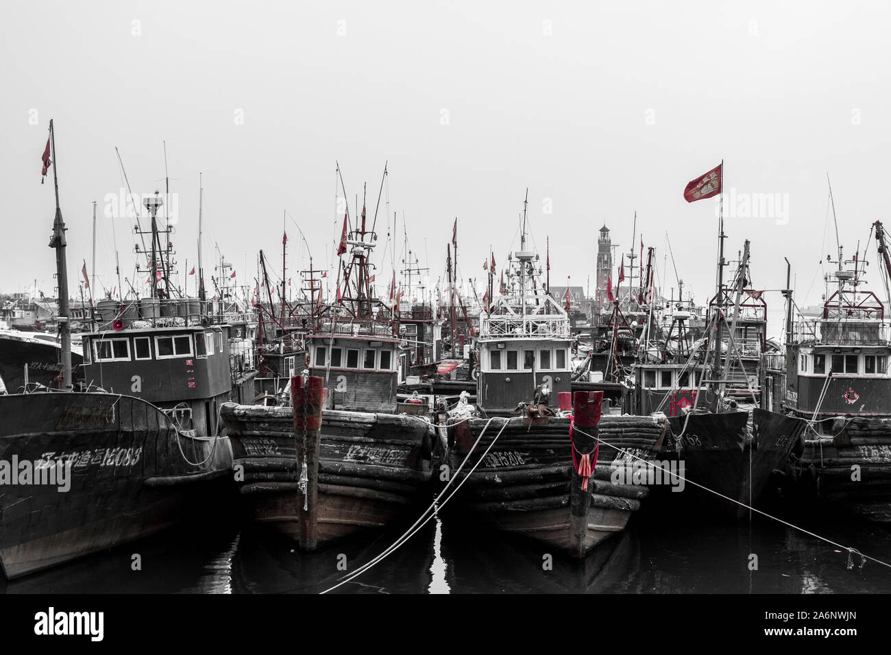Partially desaturated picture of chinese boats, during cloudy weather, parked in Dalian harbor, China, 22-8-19 Stock Photo