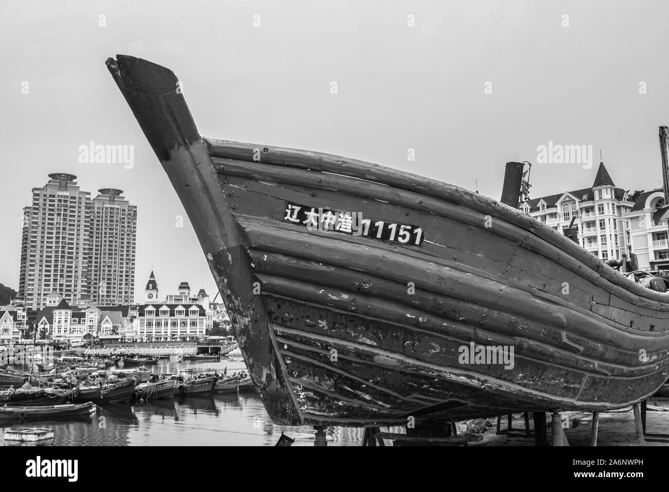 Old boat and new buildings in background. Black and white picture,Dalian, China, 22-8-19 Stock Photo
