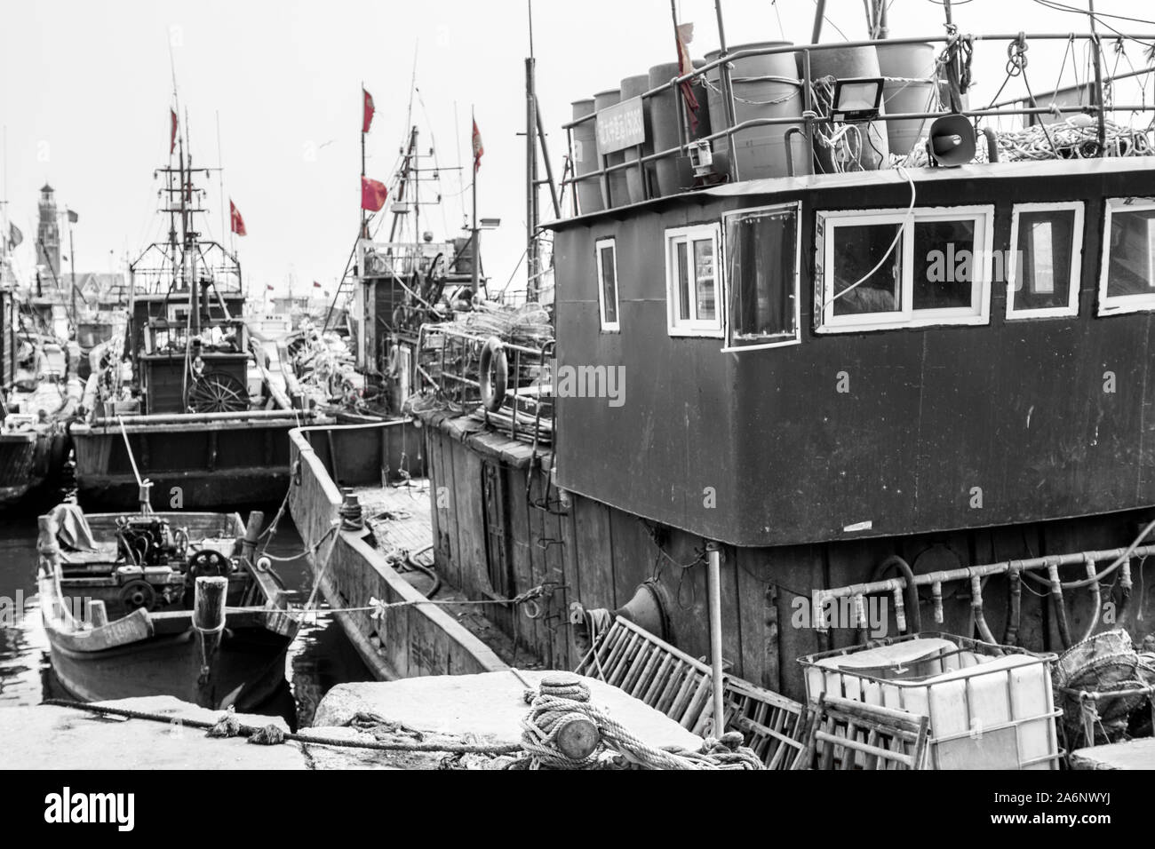 Partially desaturated Black, white and red Picture of old fisherman boat in Dalian harbor, China, 22-8-19 Stock Photo