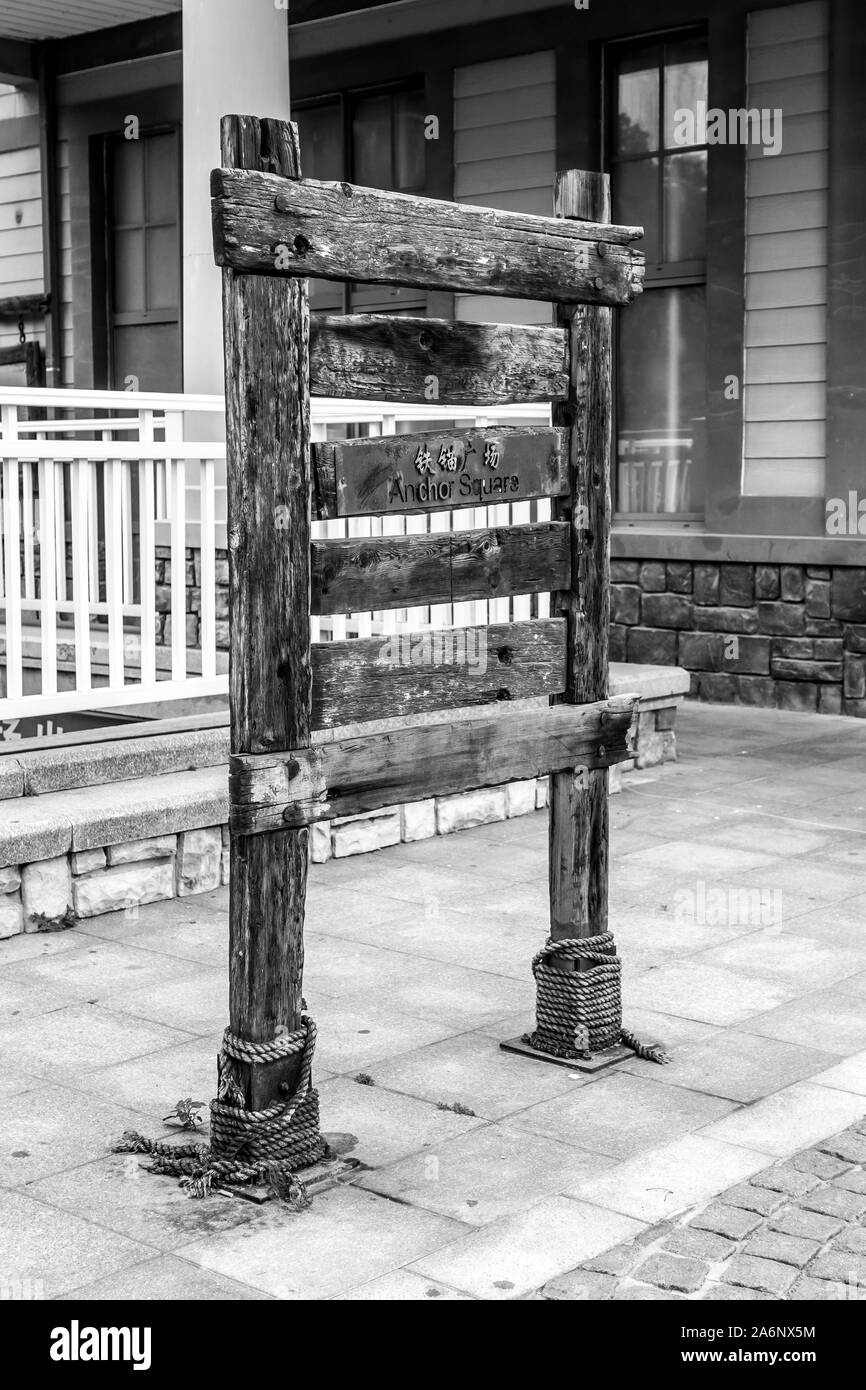 Old wooden sign of Anchor Square in chinese old harbor. high dynamics Black and White picture Stock Photo