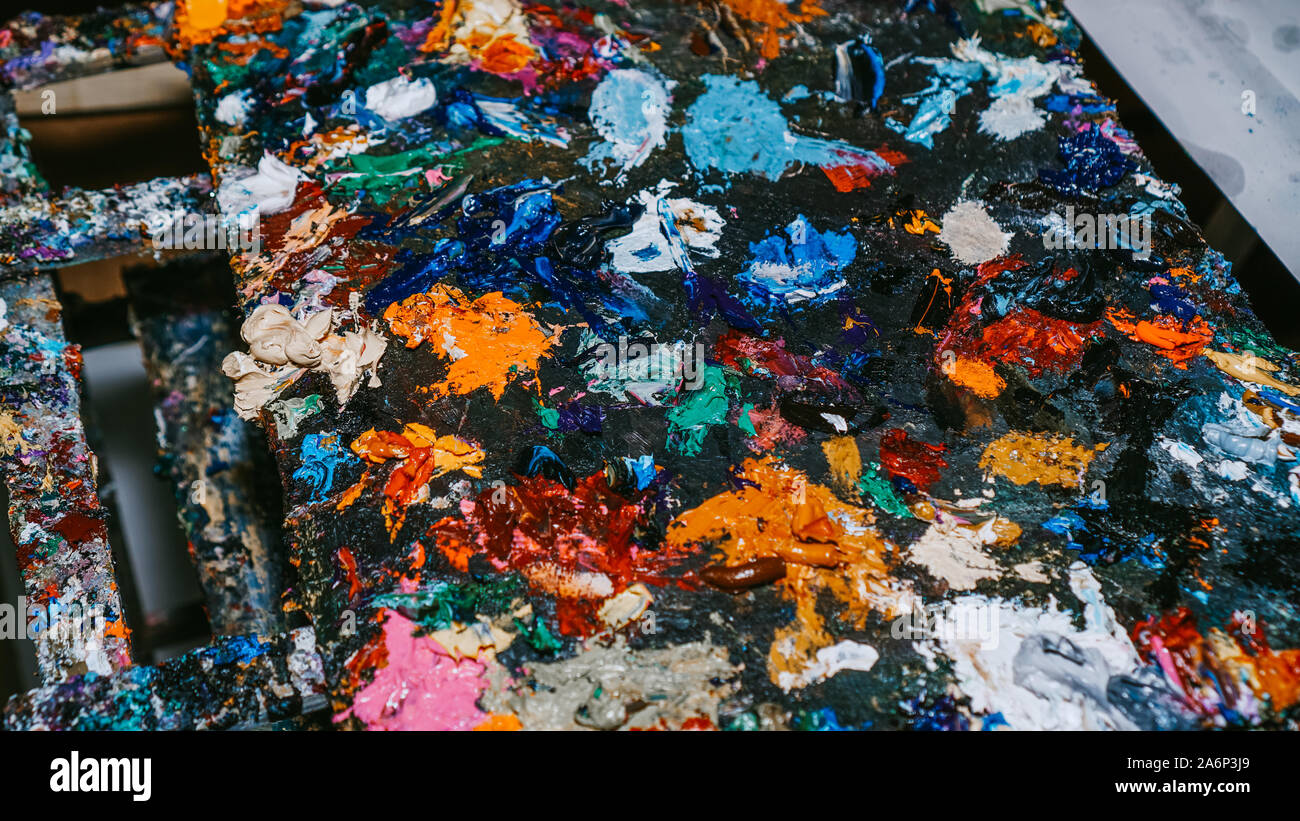 Background image of bright multi-colored oil-paint palette closeup ...