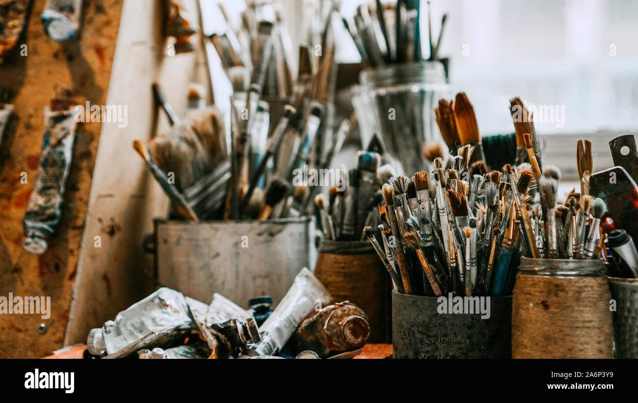 Table with brushes and tools in an art workshop. Background. Stock Photo