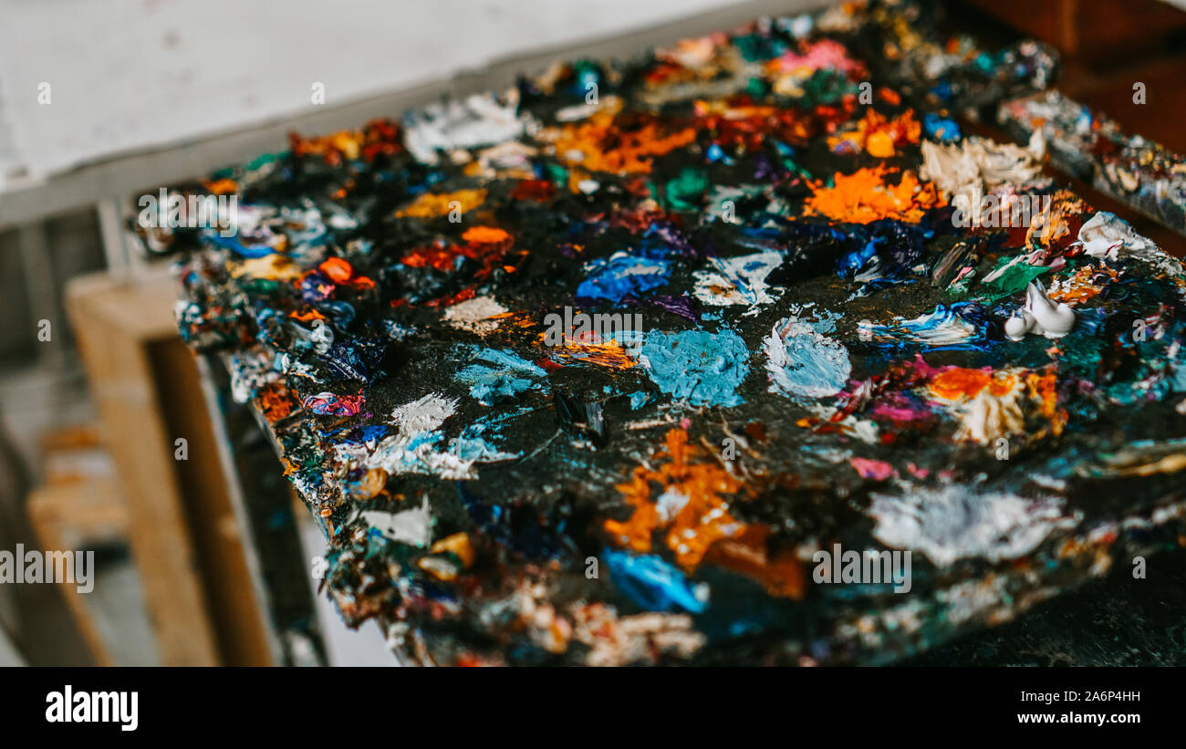 Background image of bright multi-colored oil-paint palette closeup ...