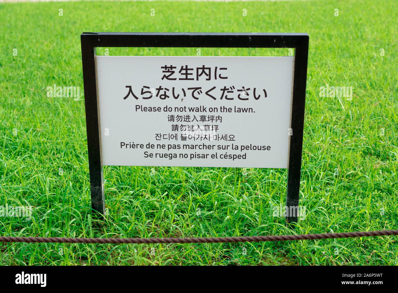 Do not walk in the lawn, Sign in chinese, japanese, english, korean french and spanish. Multi language information sign Kyoto, Japan, 3 august 2019 Stock Photo