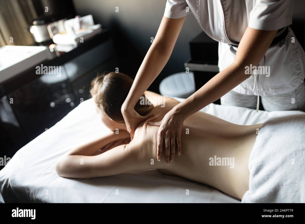 Masseur doing massage on female body in the spa salon. Beauty treatment concept. Stock Photo