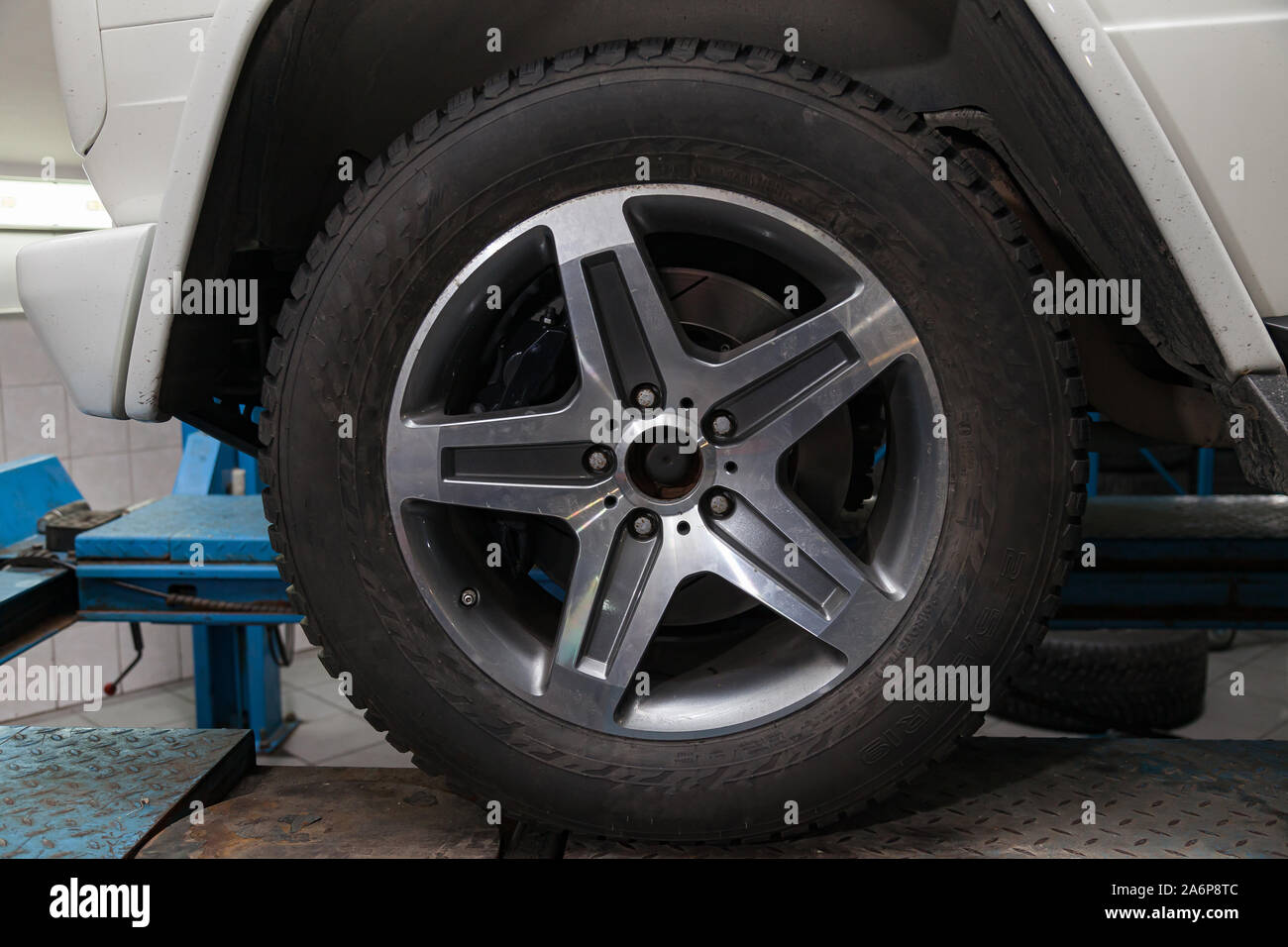 Cast aluminum rim of a car with a dressed rubber black tire on a car in ...