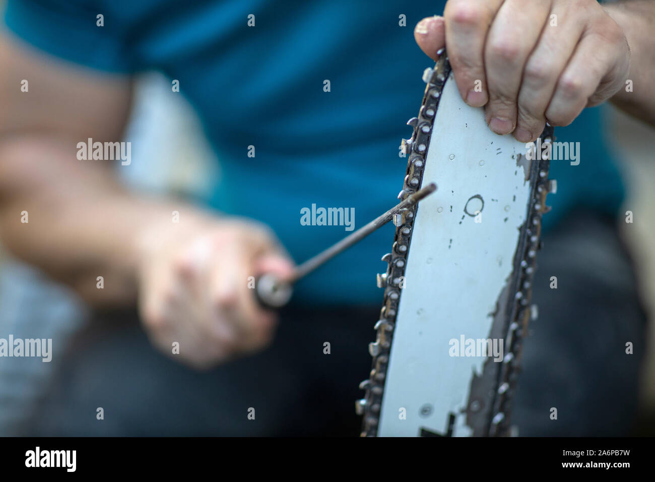 Sharpening a chainsaw Close up on a man sharpening a chainsaw chain with file Stock Photo Alamy