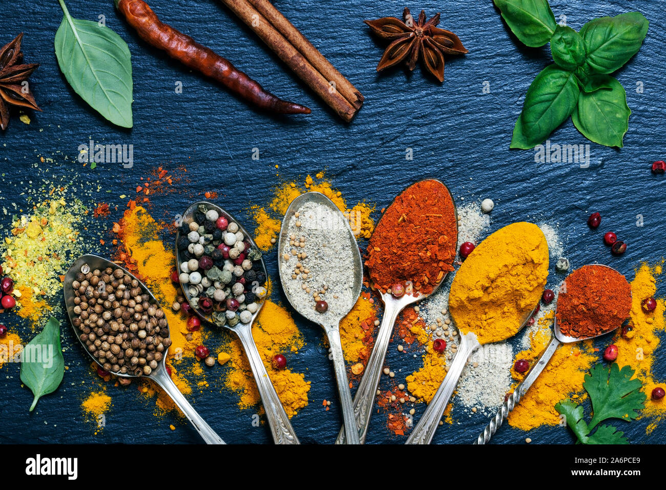 Various herbs and spices on black granite board Stock Photo