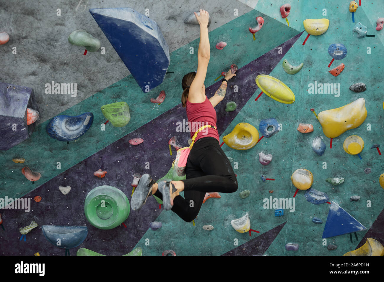 Young active woman in sportswear hanging under ceiling while holding by  handles Stock Photo - Alamy