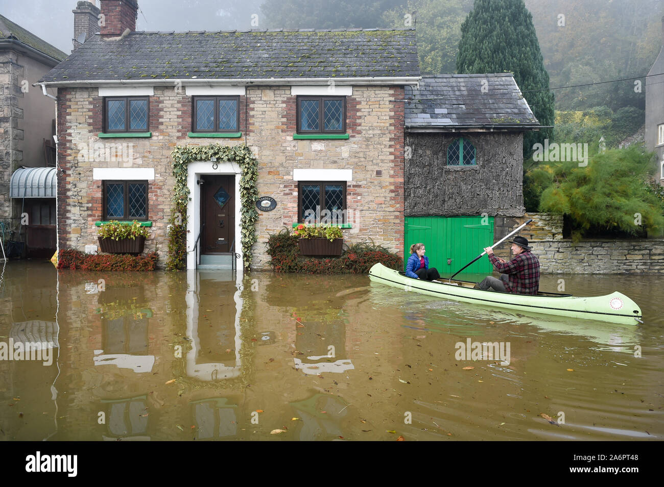 Paul Hayes ferries children to dry land after their family holiday accommodation has been surrounded by floodwater in Lower Lydbrook, where rain from the Welsh hills and high tides have flooded the village, which sits next to the banks of the River Wye, rendering it impassable. Stock Photo