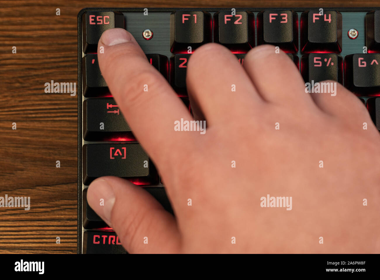 finger on keyboard presses escape Stock Photo