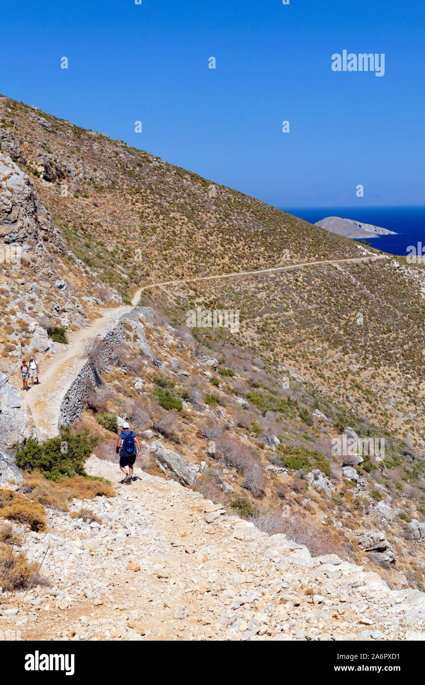 Walkers on footpath between Livadia and Gera, Tilos, Dodecanese Islands, Southern Aegean, Greece. Stock Photo