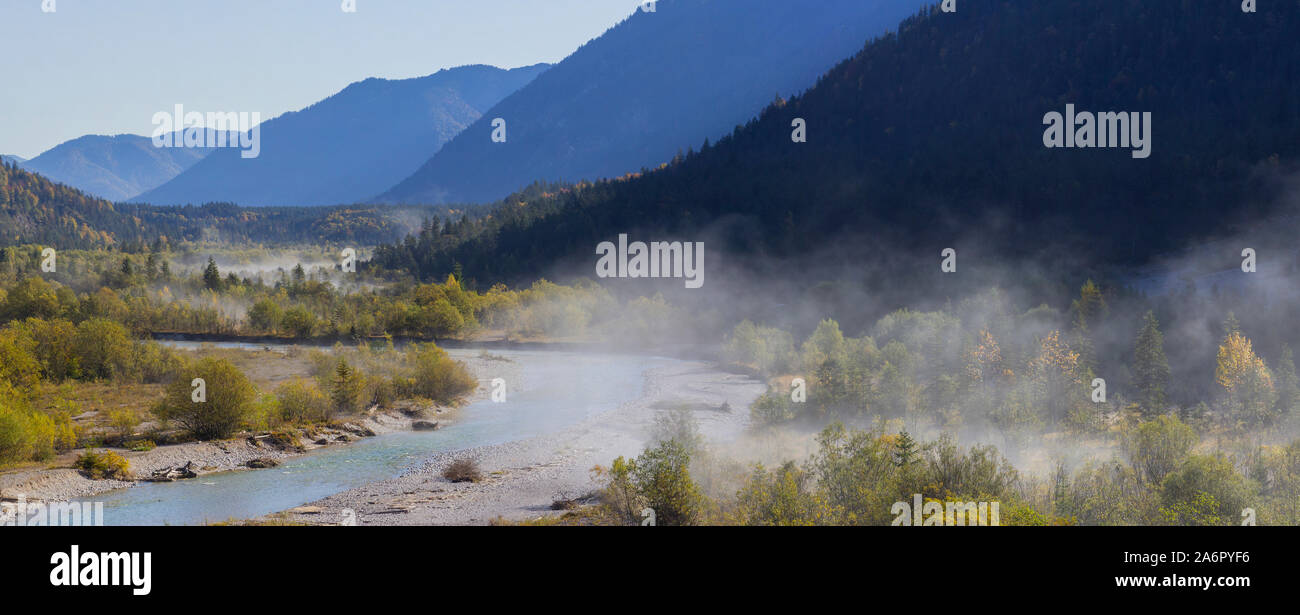Foggy trees at the river in the Isar Valley, at Vorderriss with parts of the Pfetter Kopf, the hazy Grasberg and Bruensteck Mountains, Upper Bavaria Stock Photo