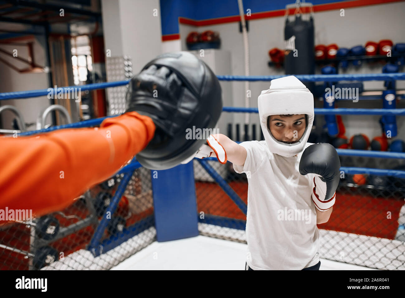 little kid boxer practicing punches with coach, close up photo Stock