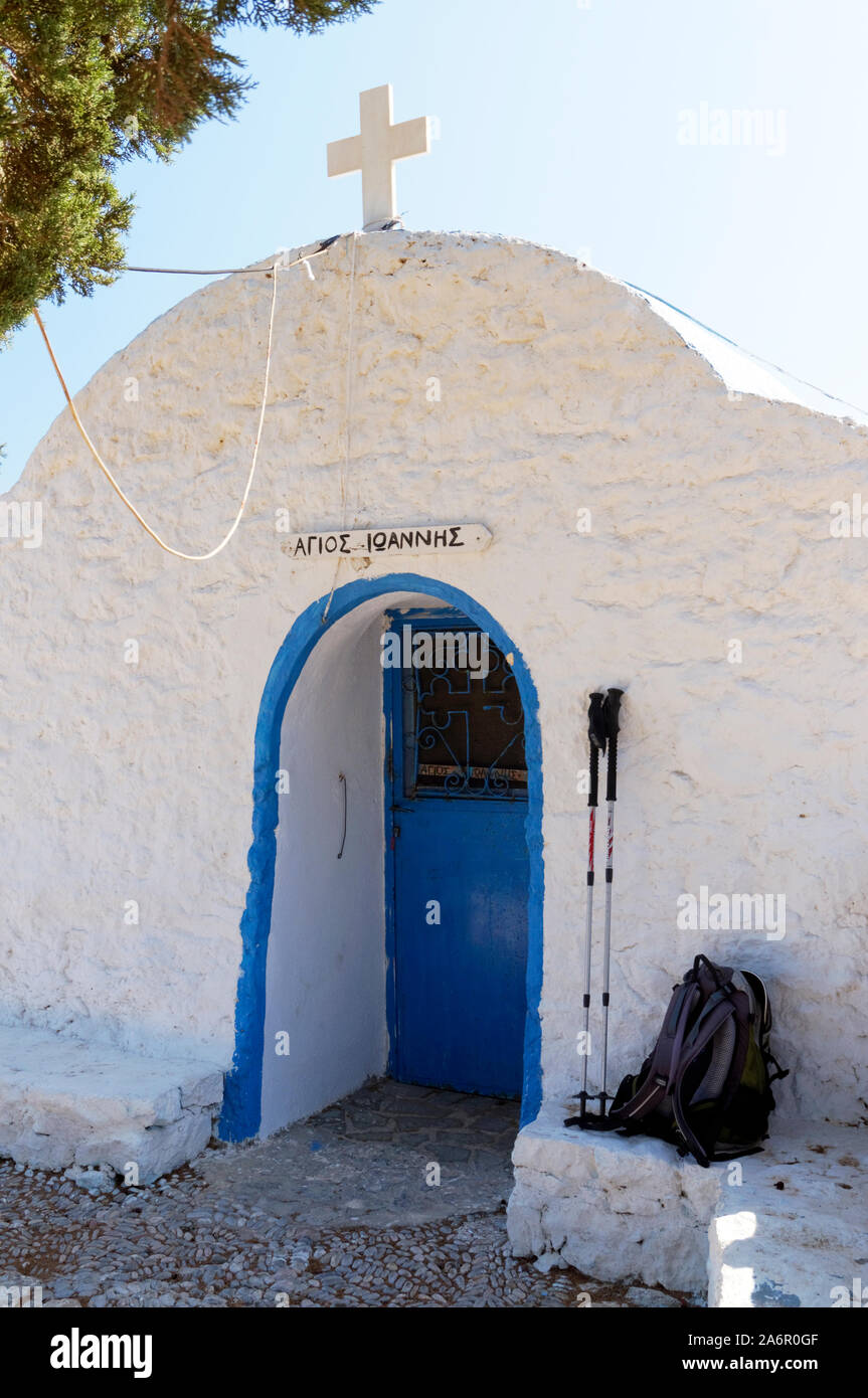 Walking poles and rucksack besides Aghios Ioannis church, livadia, Tilos, Dodecanese islands, Southern Aegean, Greece. Stock Photo