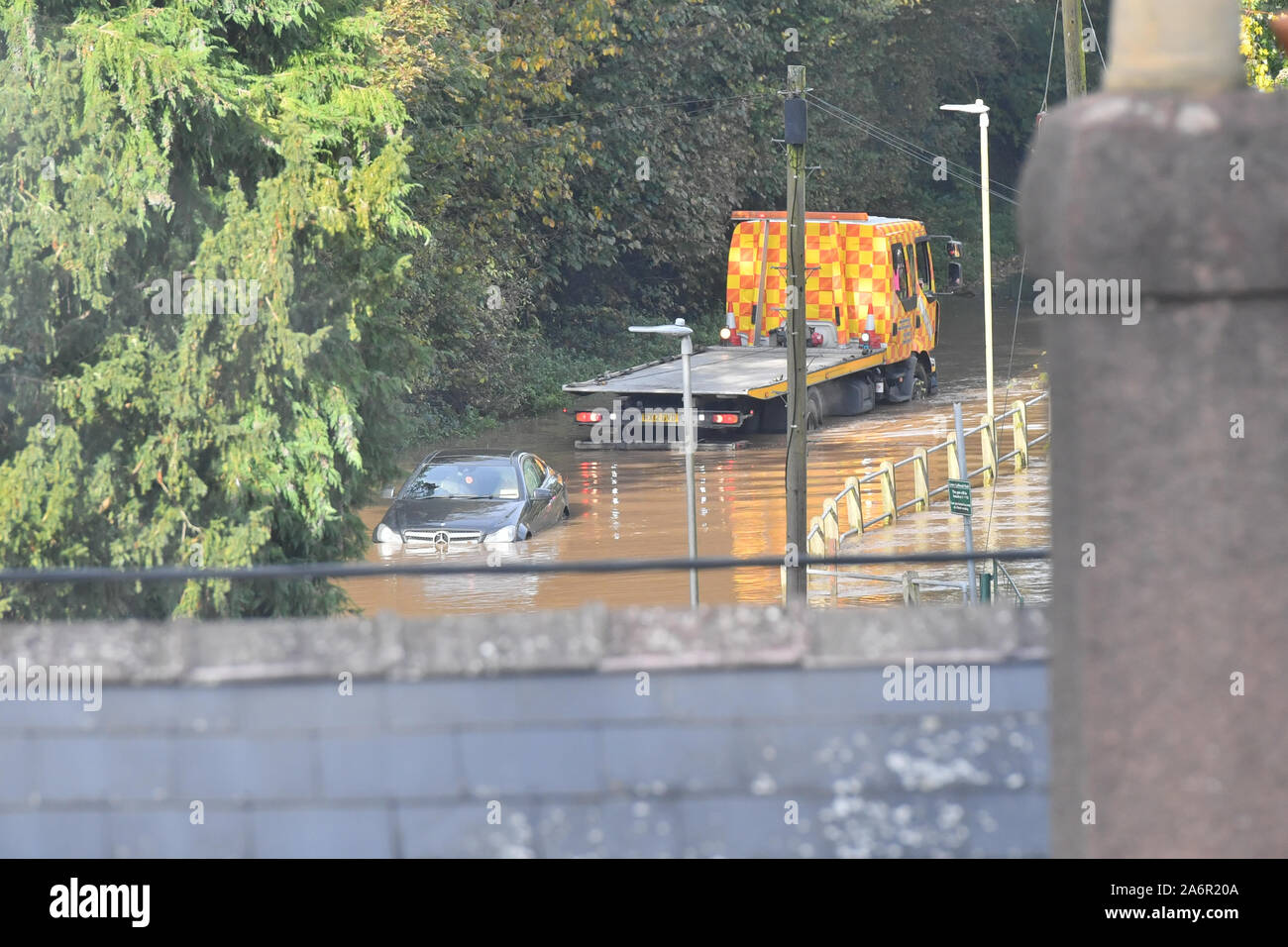 A recovery truck is driven into flood water from the River Wye in Lower Lydbrook, Gloucestershire, as its driver attempts to recover a vehicle left stranded in the water. Stock Photo