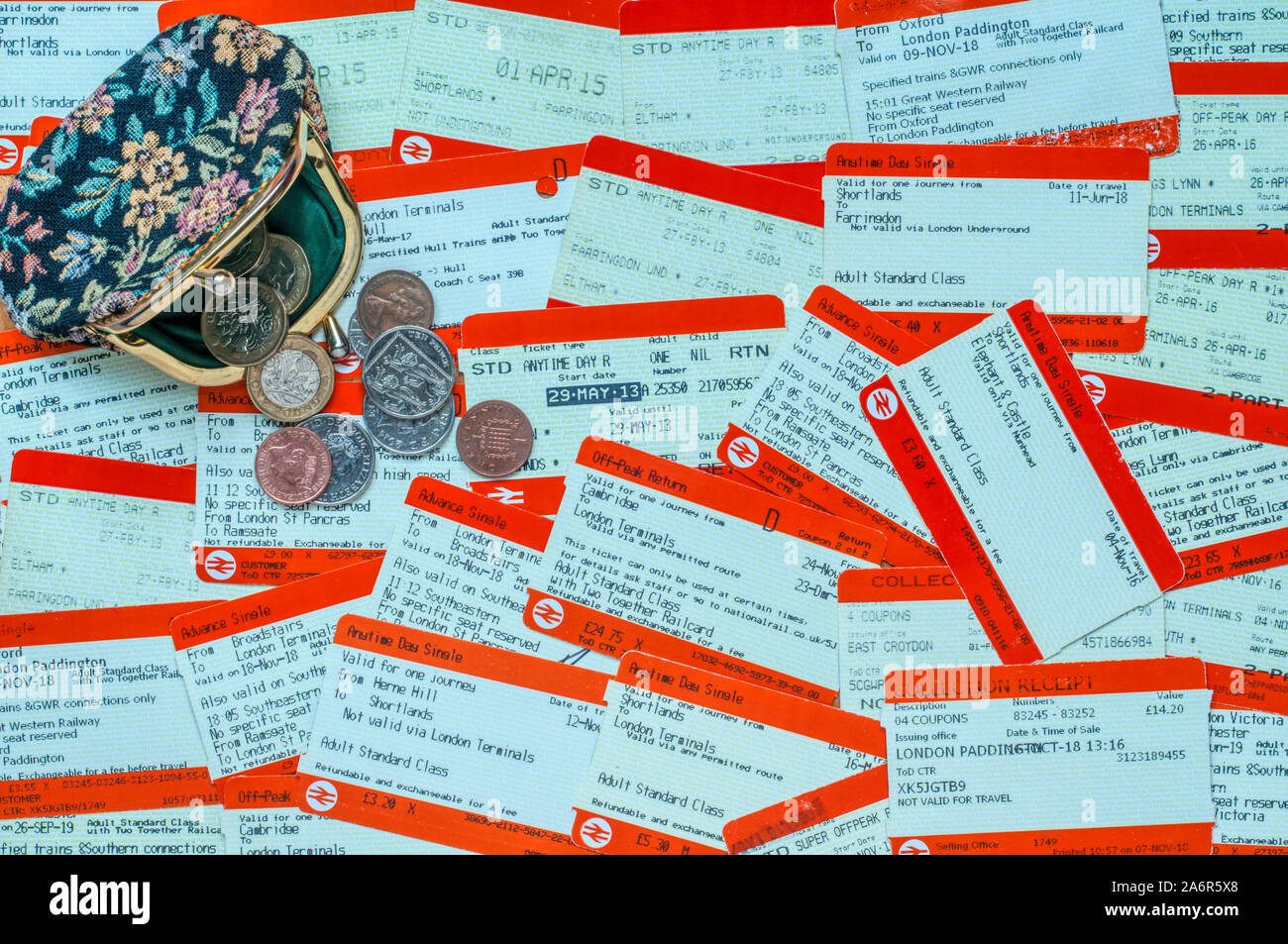 A purse and money on a pile of railway tickets.  Cost of rail travel concept. Stock Photo