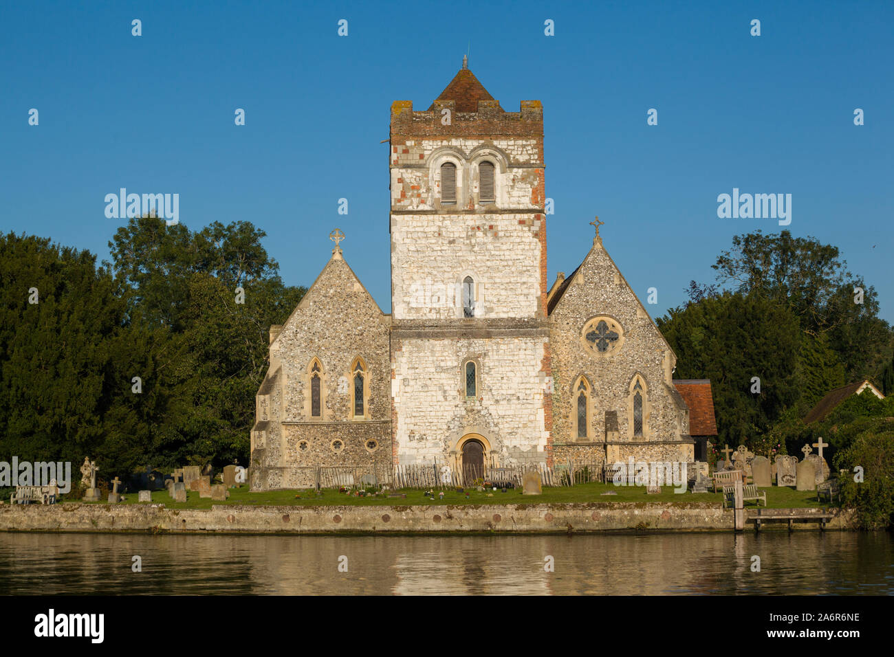 All Saints Church, Bisham, Buckinghamshire in the evening light reflected in the River Thames, Stock Photo