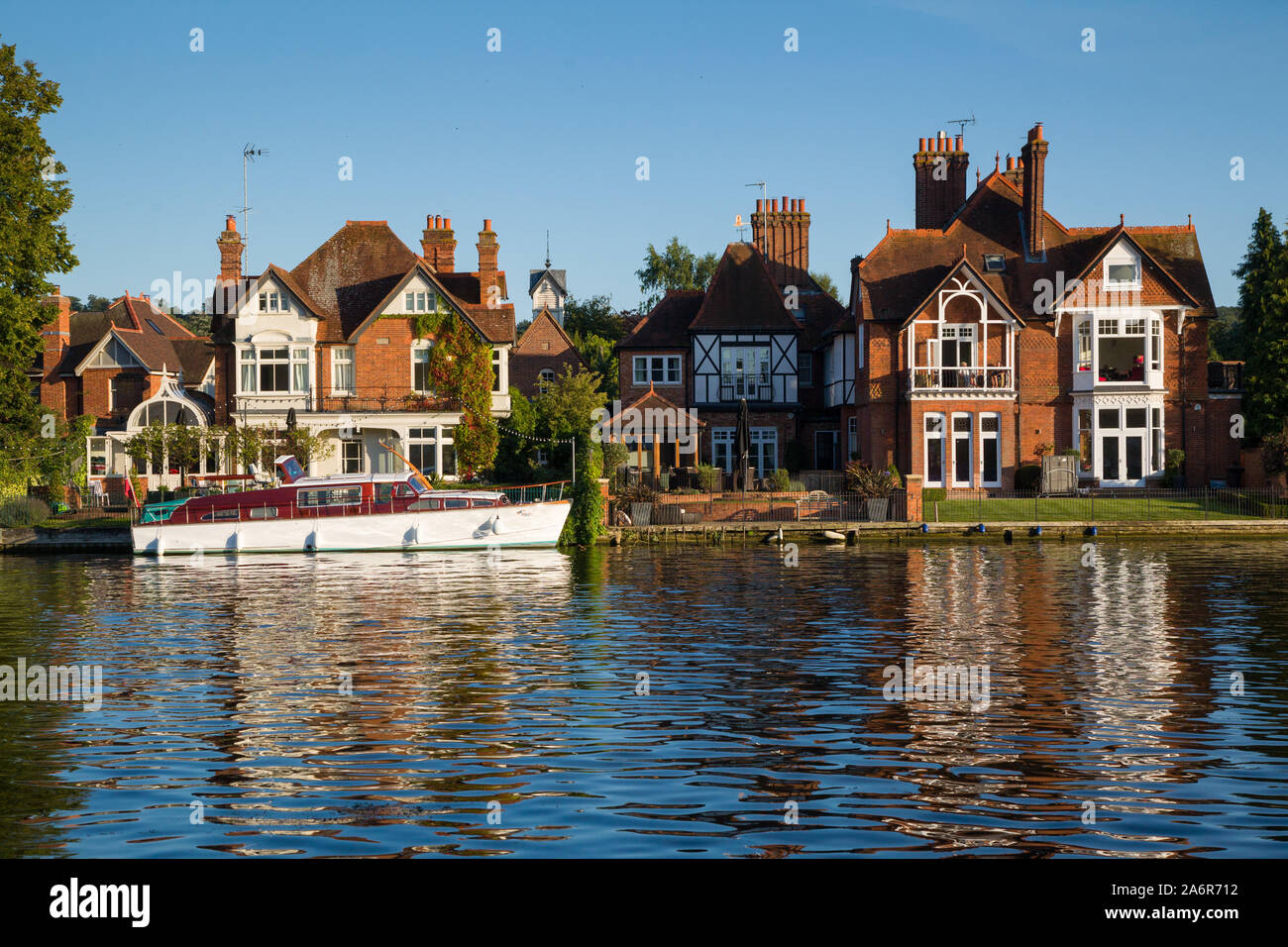 Large private residential Edwardian Villas and a classic period cabin cruiser on the Thames at Marlow, Buckinghamshire Stock Photo