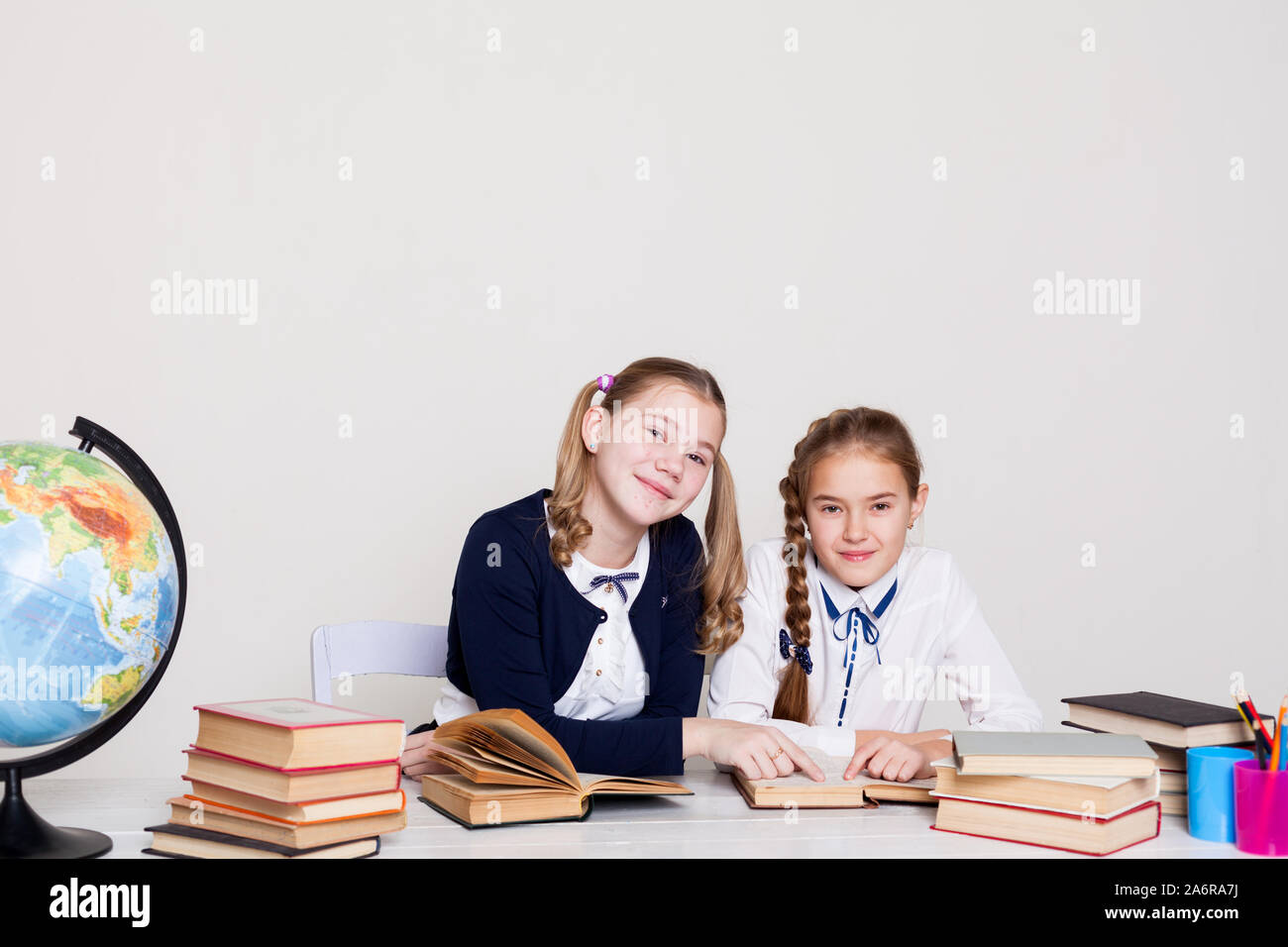 two schoolgirl girls at the desk in a geography class Stock Photo - Alamy