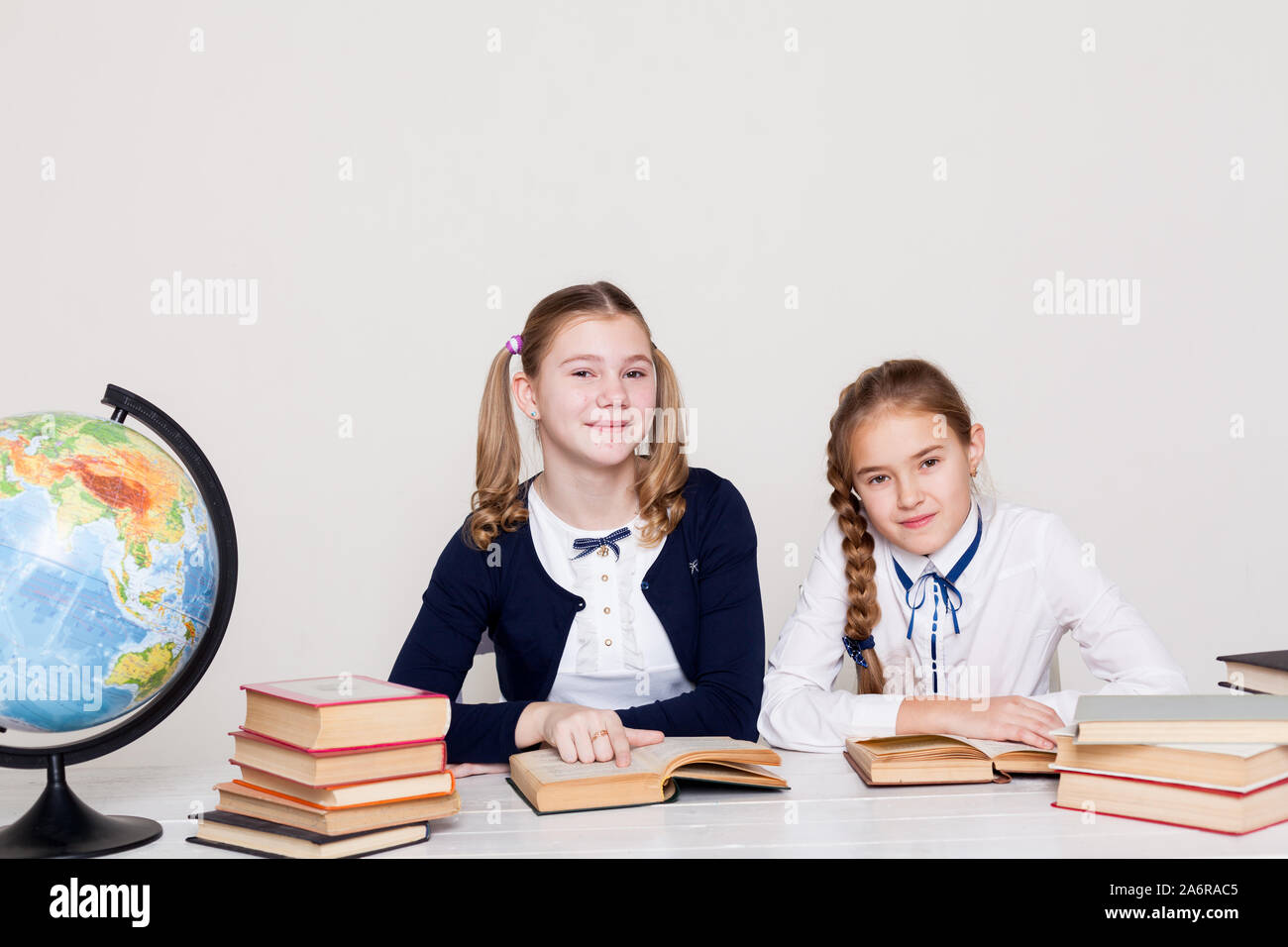 two schoolgirl girls at the desk in a geography class Stock Photo - Alamy