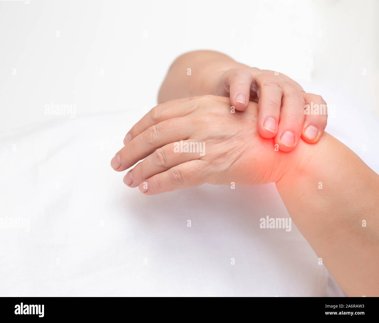 Woman holds on wrist joint on a white background. The concept of pain and inflammation of the wrist joint, tunnel syndrome and arthritis, copy space, Stock Photo